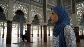 Woman in Hijab Contemplating in Mosque with Ornate Architecture photo