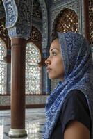 Woman in Headscarf Inside Ornate Building Looking Out Arched Window photo