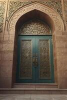 Ornate Teal Doors with Intricate Design Under an Archway Entrance photo