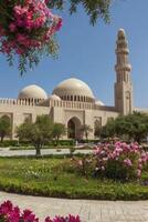 Beautiful Mosque in Oman with Pink Flowers and Lush Greenery photo