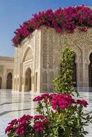 Ornate Architecture with Vibrant Flowers on Building Exterior Under Clear Sky photo