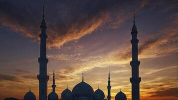 Mosque Silhouette at Sunset with Dramatic Sky in Middle East photo