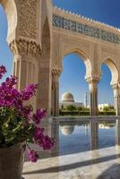 Mosque View Through Ornate Arches with Purple Flowers and Reflections photo