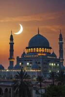Mosque Architecture at Sunset with Crescent Moon Glowing in Warm Sky photo