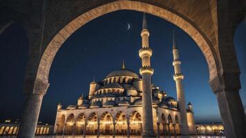 Illuminated Mosque at Night Through Stone Arches with Crescent Moon photo