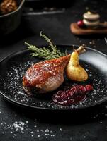 Roasted Duck Leg Served with Pear and Cranberry Sauce on Plate photo