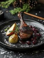 Roasted Duck Leg Garnished with Pears and Cherries on a Plate photo