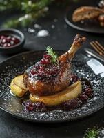 Roasted Duck Leg with Cranberry Sauce and Pear Slices on Plate photo