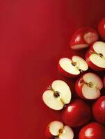 Arrangement of Sliced and Whole Red Apples on a Red Background photo