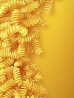 Fusilli Pasta Background on Yellow Surface with Copy Space for Text photo