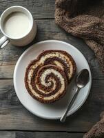 Enjoying Chocolate Cake Roll with Milk and a Spoon on Wood Table photo