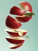 Sliced Red Apple Floating with Green Leaves Against a Clean Background photo