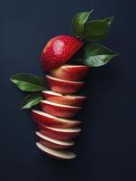 Sliced Red Apple Composition on Dark Background with Green Leaves photo