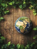 Earth Globe Surrounded by Green Leaves on Wooden Background for Ecology photo