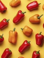Red and Orange Bell Peppers Pattern on Yellow Background Flat Lay photo