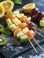 Making Healthy Fruit Skewers with Fresh Orange Apple and Grapes photo