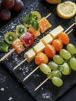 Arrangement of Fresh Fruit Skewers with Cheese on a Slate Board photo