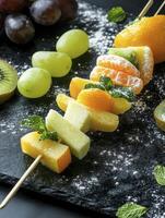 Arranged Fruit Skewers with Grapes and Kiwi on Slate Background photo