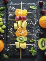 Arrangement of Colorful Fresh Fruit Skewers with Grapes and Mint Leaves photo