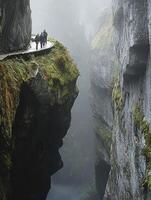 People Walking on Cliff Path Above Steep Canyon in Misty Weather photo