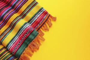 Colorful Striped Fabric with Fringe on Bright Yellow Background Design photo