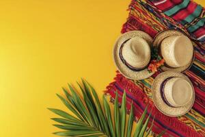Arrangement with Straw Hats and Palm Leaf on Bright Yellow Background photo
