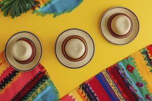 Arrangement of Straw Hats and Colorful Textile on Yellow Background photo