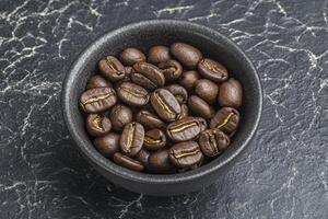 Coffee Beans in a Bowl Close-up on a Dark Marble Background photo