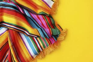 Striped Mexican Serape Blanket on Yellow Background with Vibrant Colors Texture photo