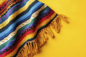 Striped Poncho with Yellow Fringe on Bright Background for Mexican Theme photo