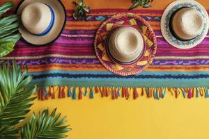 Arrangement of Straw Hats on Colorful Textile with Tropical Palm Leaves photo