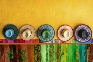 Colorful Sombrero Hats Arranged on Yellow Wall with Traditional Woven Textile photo