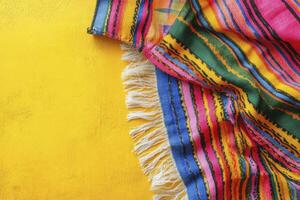 Striped Textile with Fringe on Yellow Background Creates Vibrant Presentation photo