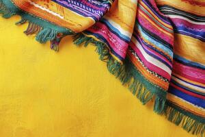 Colorful Striped Textile with Fringes on a Yellow Textured Background photo