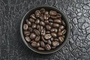 Roasted Coffee Beans in a Bowl on a Textured Dark Surface photo