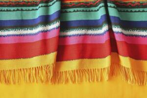 Striped Colorful Textile with Fringe on Yellow Surface for Backdrop Usage photo