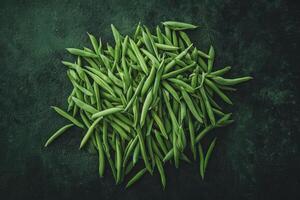 Fresh Green Beans Scattered on a Dark Textured Surface for Cooking photo
