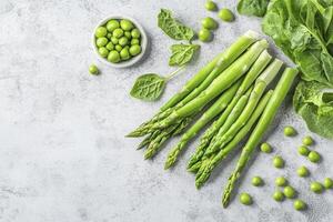 Asparagus with Green Peas and Spinach on Grey Surface Still Life photo
