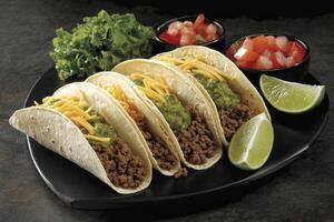 Delicious Tacos with Ground Beef Toppings and Fresh Lime Wedges on Plate photo