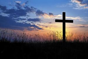 Christian Cross Silhouette with Colorful Sunset Sky and Tall Grass photo