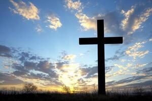 Cross Silhouette Against a Colorful Sky at Sunset Religious Symbol photo