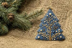 Festive Christmas Tree Ornament with Pine Branch and Burlap Background photo
