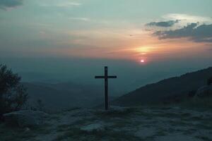 Cross Silhouette on Hilltop at Sunset with Soft Hues and Mountains photo