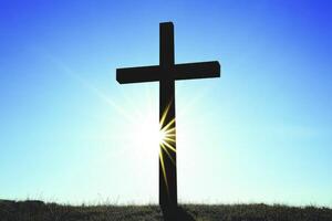 Silhouette of Cross Against Sunlight and Blue Sky Symbolic Image photo