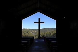 Cross Silhouette in Church with View of Hills and Clear Blue Sky photo