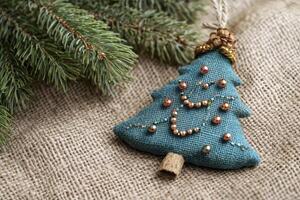 Handmade Christmas Tree Ornament with Evergreen Branch on Burlap Fabric photo