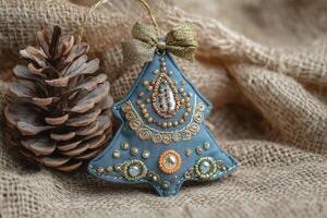 Handmade Christmas Tree Ornament with Pinecone on Burlap Background photo