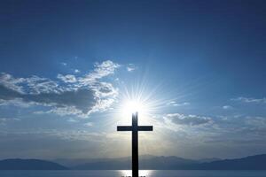 Christian Cross Silhouette Against Sunny Sky and Lake Landscape Background photo