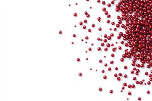 Scattering of Shiny Red Sugar Pearls on a Clean White Background photo