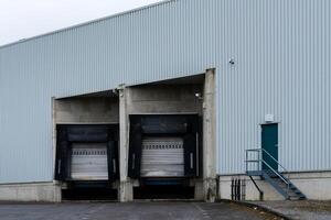 Two loading docks lie side by side at a commercial warehouse under an photo
